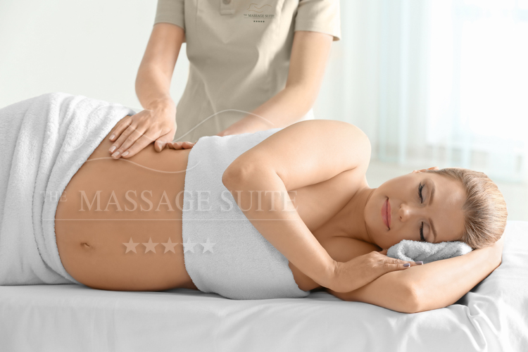 Ξανθιά έγκυος γυναίκα που βρίσκεται κατά τη διάρκεια της υπηρεσίας Μασάζ Εγκυμοσύνης στο The Massage Suite